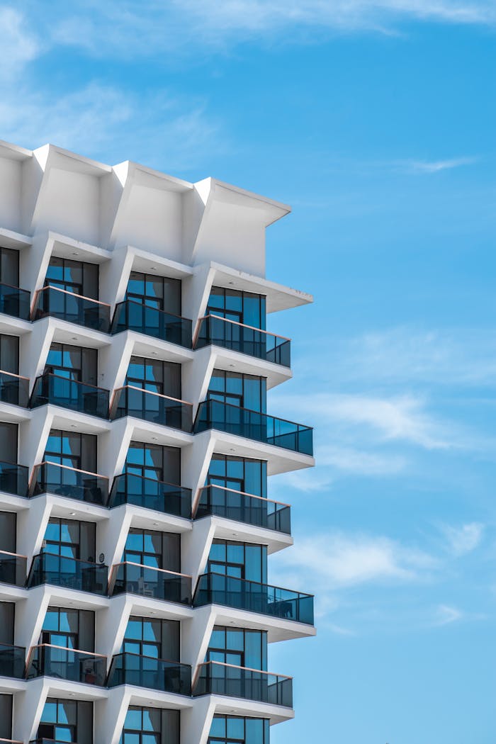 Contemporary Dubai apartment building with geometric balconies under clear blue sky.