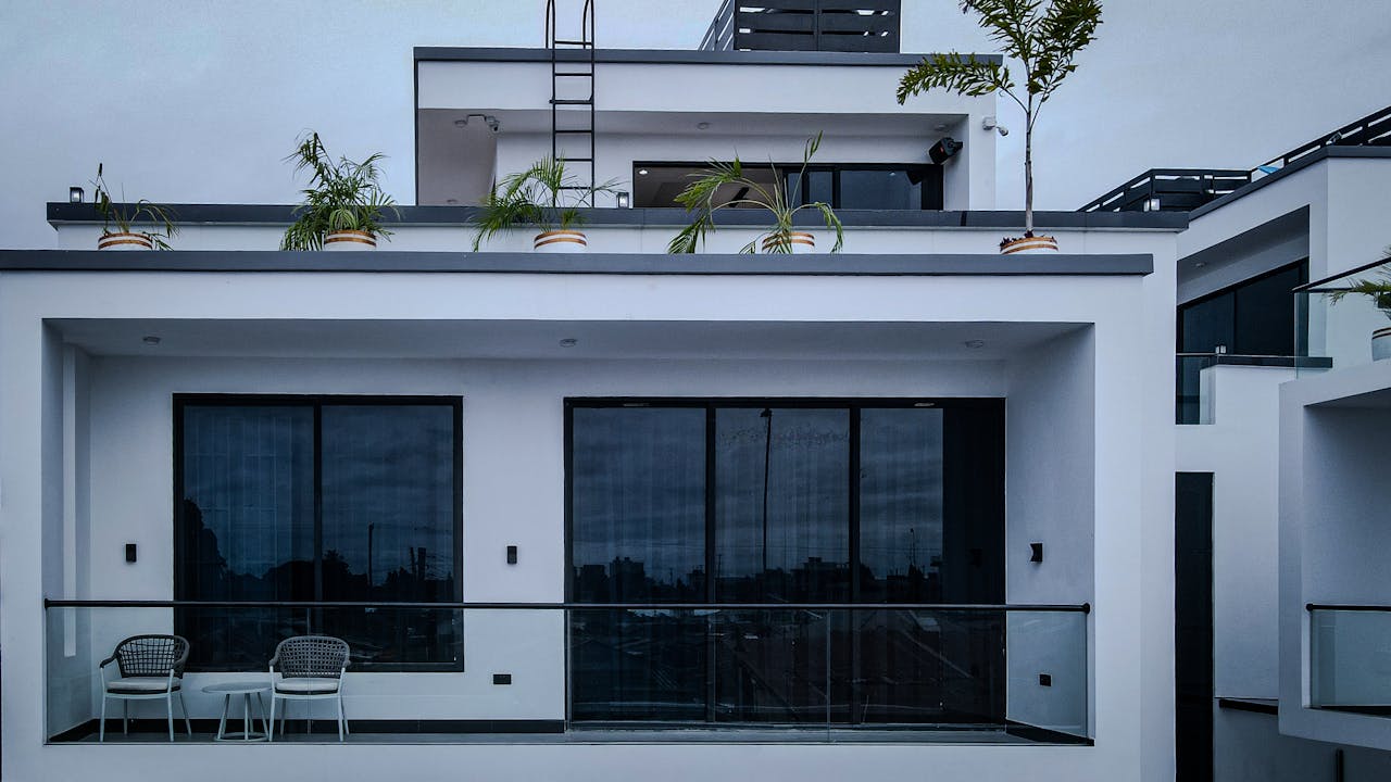 Stylish white building with balconies and potted plants in Dar es Salaam, Tanzania.